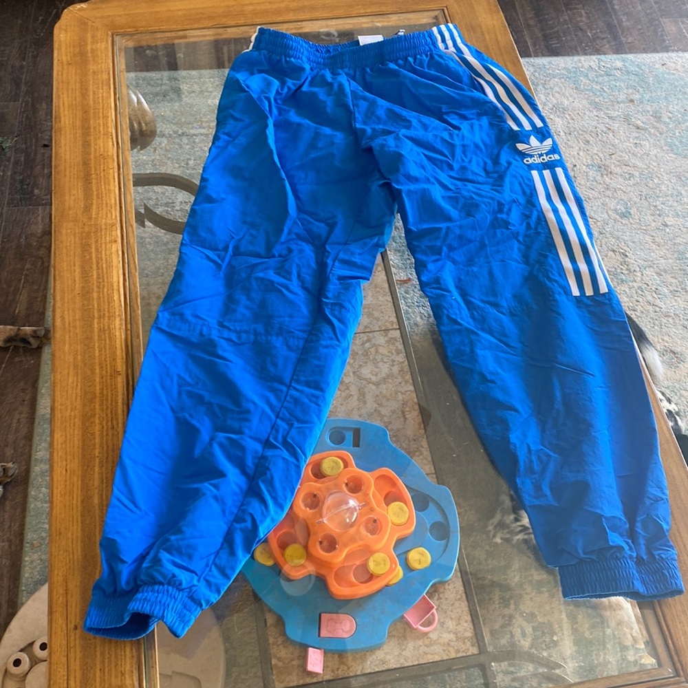 They are large blue adidas sweats with white stripes